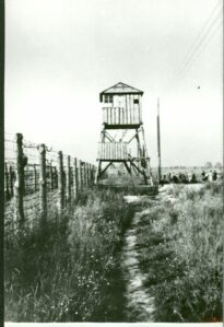 Lipiec 1944. Ogrodzenie i wieże obserwacyjne na terenie b. obozu, prawdopodobnie przy pierwszym międzypolu. W tle drzewa przy szosie piaseckiej.