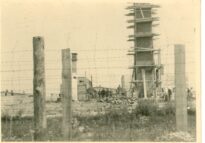 Widok na spalone krematorium na Majdanku od strony południowo-zachodniej w lecie 1944 r. Doskonale widoczny osłabiony na skutek pożaru komin krematorium wzmocniony deskami. Po lewej stronie zdjęcia piece krematoryjne, Na pierwszym planie podwójne ogrodzenie krematorium.