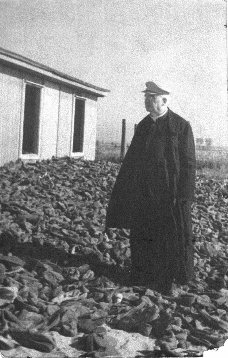 Ks. infułat Józef Kruszyński (1877-1953) na VI polu w pobliżu baraku z butami.