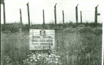 Tablica ostrzegawcza o treści "UWAGA! STREFA ŚMIERCI" na jednym z pól więźniarskich. Tekst powtórzony w języku niemieckim, polskim i rosyjskim.