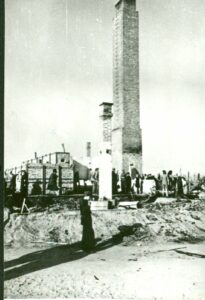 Pozostałości spalonego krematorium od strony południowo-wschodniej. Na pierwszym planie niewielki komin (znajdujący się wewnątrz pomieszczenia esesmanów), za nim główny komin krematorium, w głębi mniejszy komin nad komorą gazową. Z lewej piece krematorium.