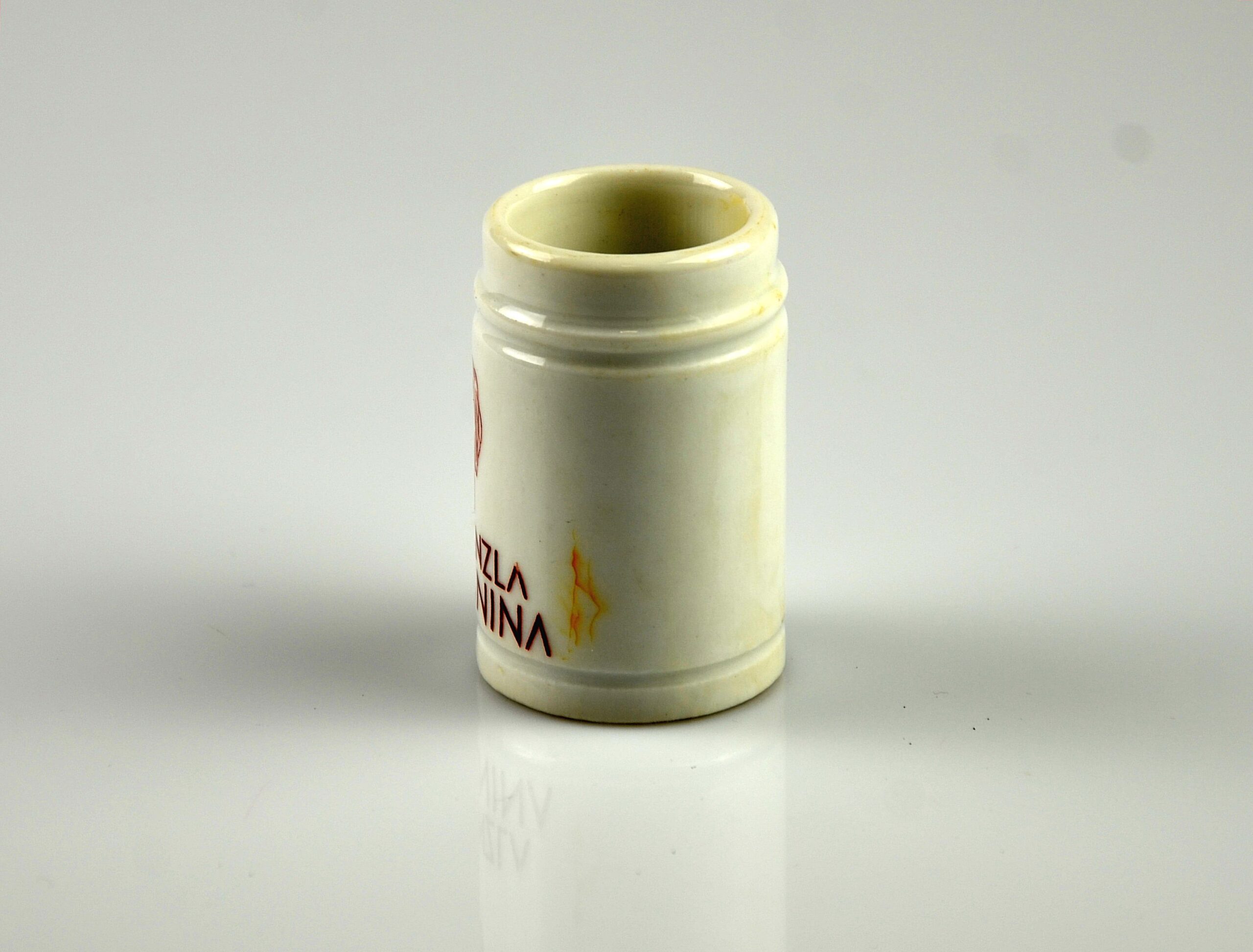 Pojemnik ceramiczny z napisem: DRA. STENZLA BENIGNINA i grafiką w postaci twarzy kobiety.